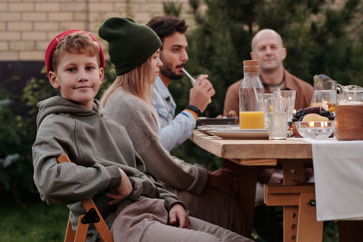 Group of relatives enjoying dinner with beverages outdoors